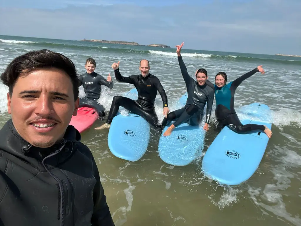 Groupe surf Essaouira — selfie en mer avec planches Elite School